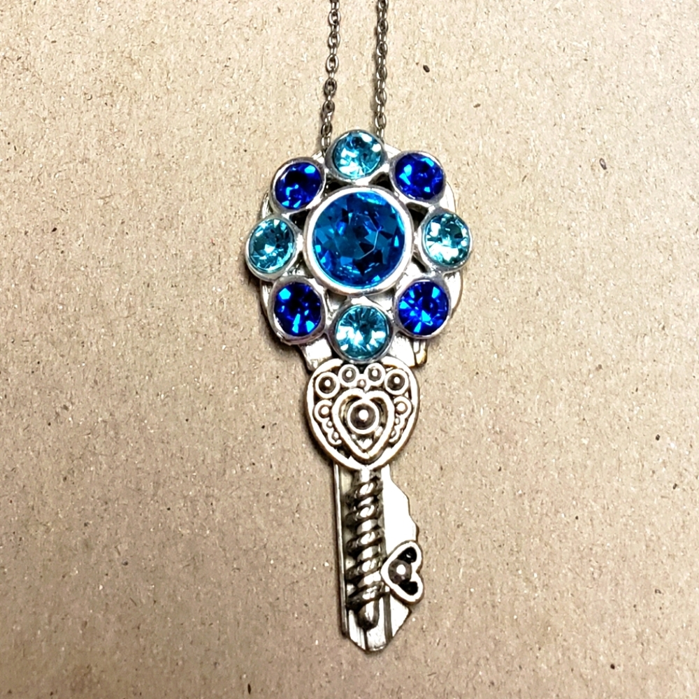 Silver bejeweled key necklace.